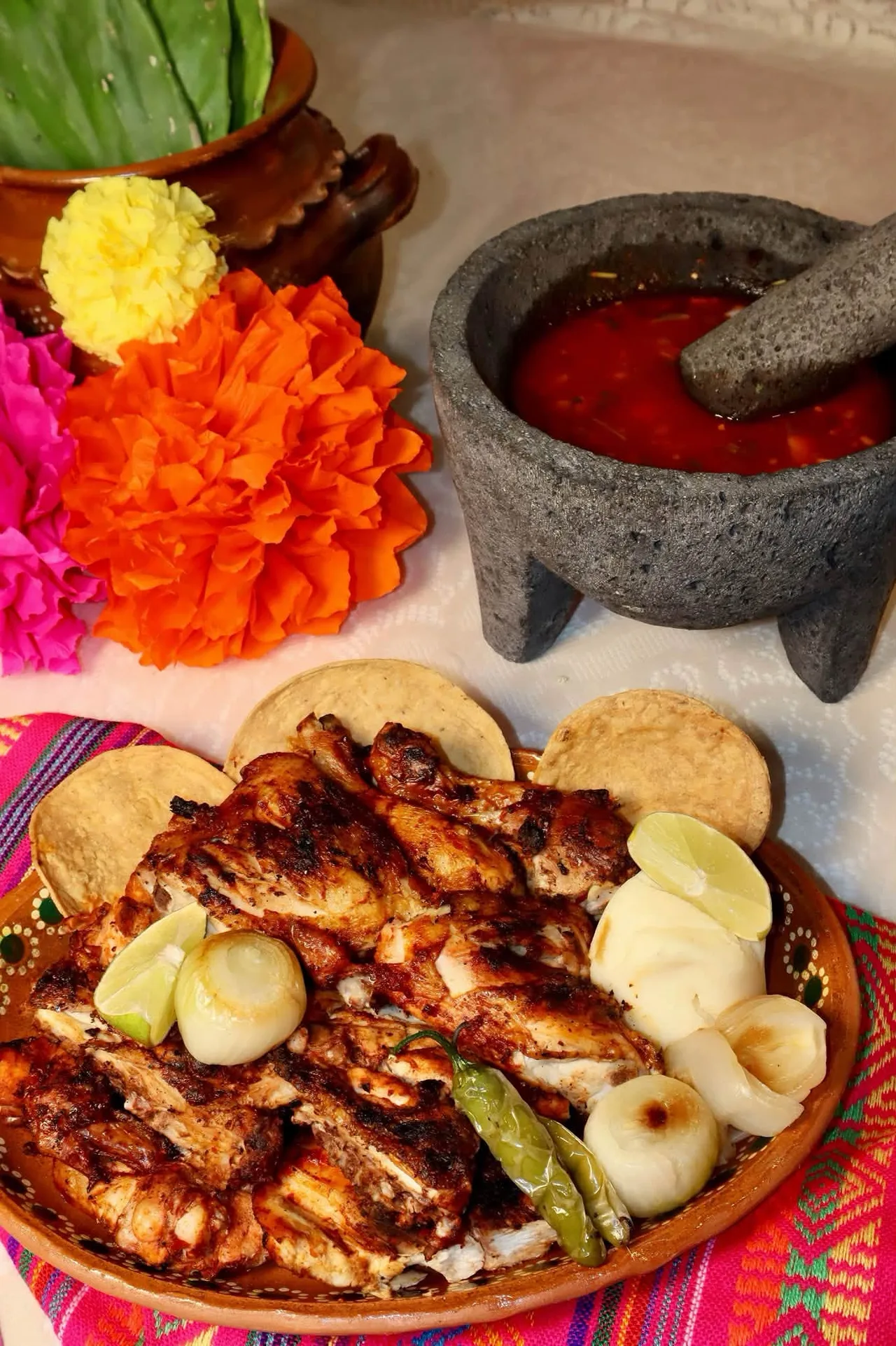 Pollo asado La Colmena con cebollitas, chiles, limones y tostadas